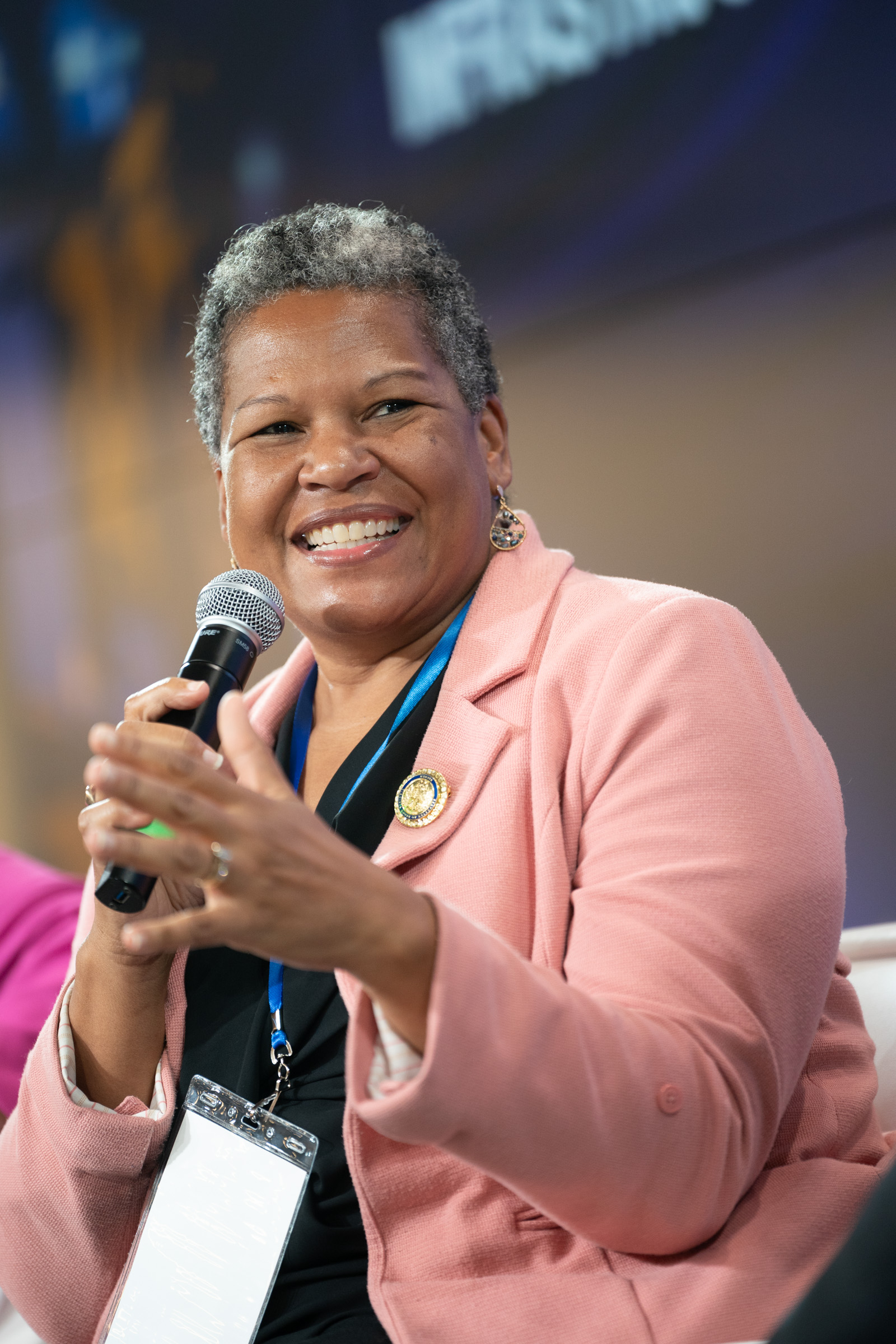 Conference speaker smiling while holding a microphone