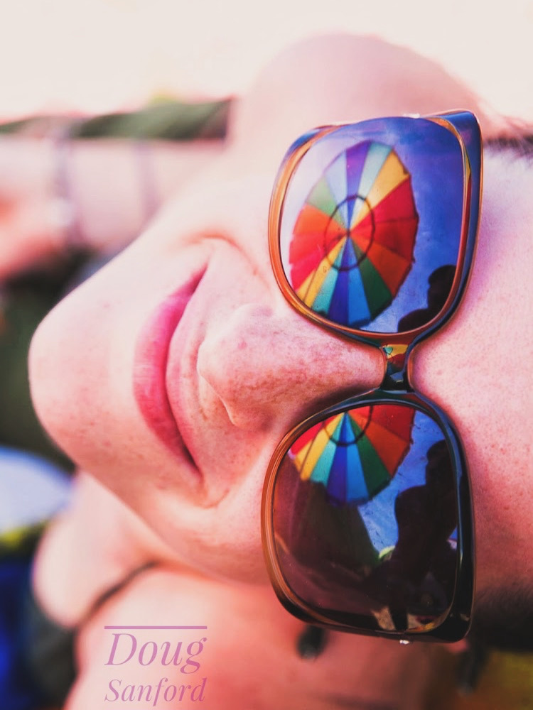 Close portrait reflected in vivid rainbow sunglasses